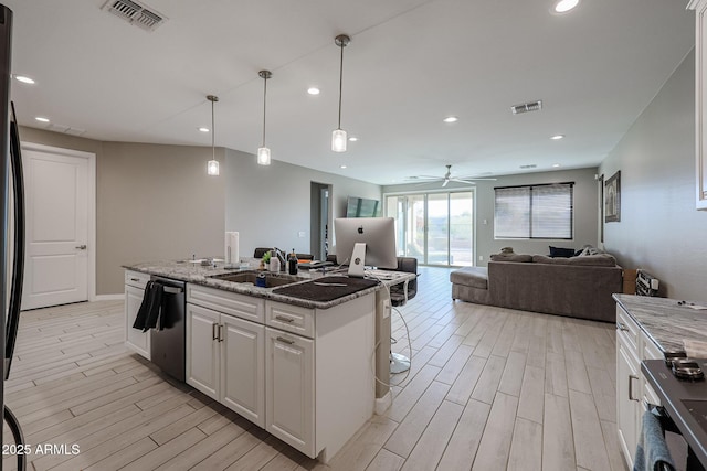 kitchen featuring pendant lighting, white cabinetry, dishwasher, an island with sink, and dark stone counters