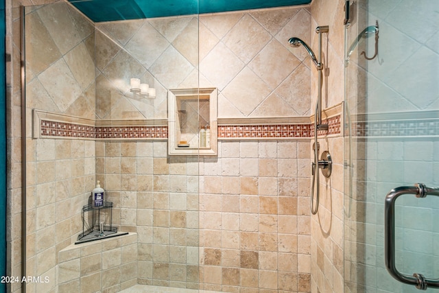 bathroom featuring a shower with shower door