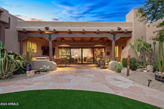 patio terrace at dusk featuring ceiling fan and a pergola