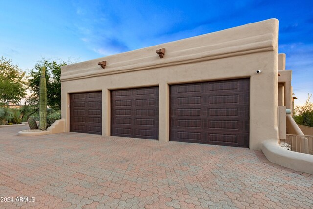 view of garage at dusk