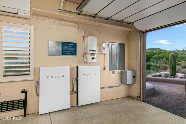 garage with an AC wall unit and electric panel