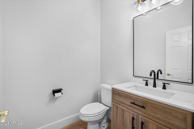 bathroom with hardwood / wood-style floors, vanity, and toilet