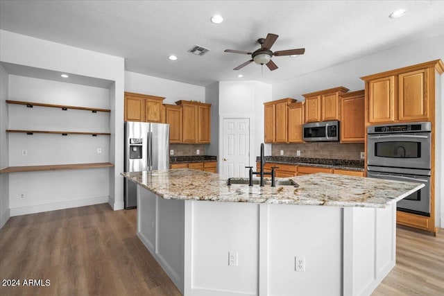 kitchen with decorative backsplash, a large island, sink, and stainless steel appliances