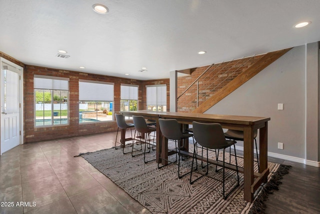 4304 W Calle Poco, Laveen, AZ 85339 - dining area with brick wall, recessed lighting, and stairs