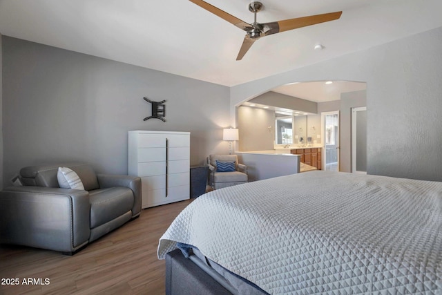 4304 W Calle Poco, Laveen, AZ 85339 - bedroom with arched walkways, wood finished floors, ceiling fan, and ensuite bath