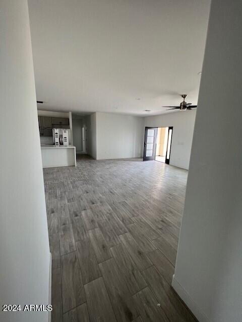 unfurnished living room with ceiling fan and hardwood / wood-style floors