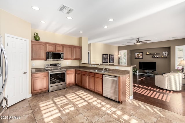 kitchen featuring visible vents, open floor plan, recessed lighting, a sink, and appliances with stainless steel finishes