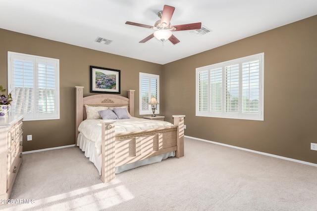 bedroom with visible vents, light carpet, and multiple windows