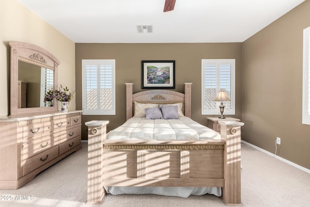 bedroom with light colored carpet, baseboards, visible vents, and a ceiling fan