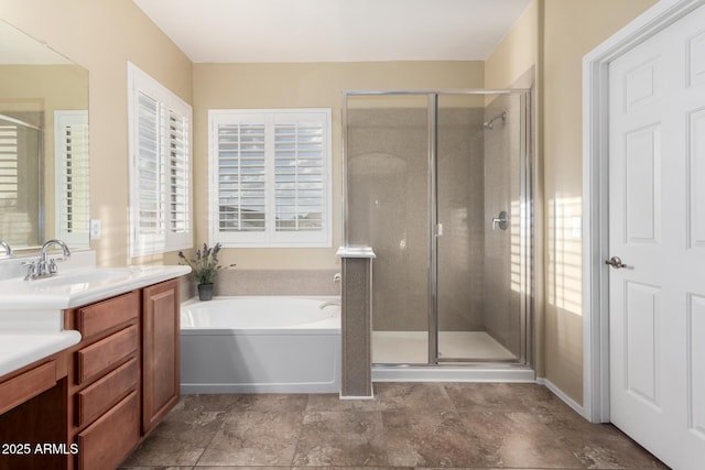bathroom with vanity, a shower stall, a bath, and a wealth of natural light