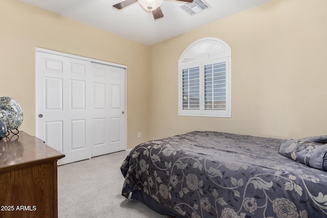 carpeted bedroom featuring a ceiling fan, a closet, and visible vents