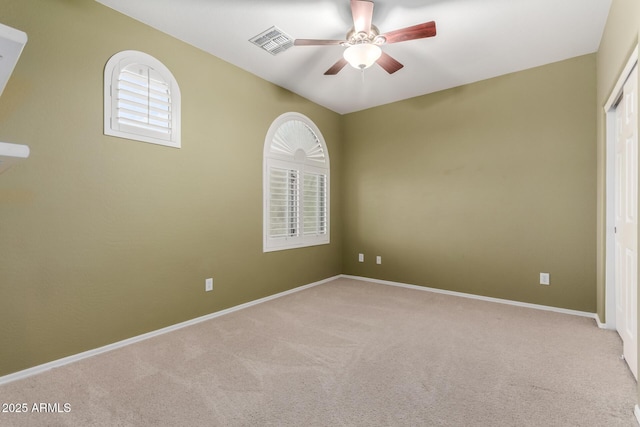 carpeted spare room featuring baseboards, a ceiling fan, and visible vents