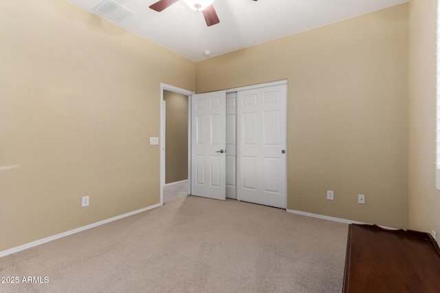 unfurnished bedroom with baseboards, light carpet, a closet, and visible vents