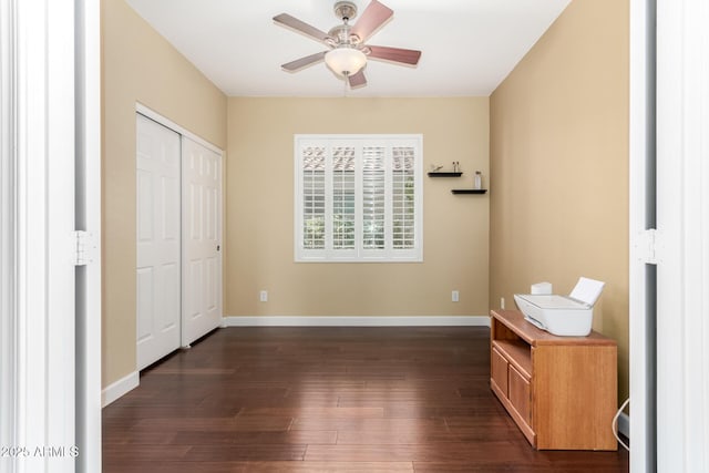 unfurnished bedroom with dark wood-style flooring, baseboards, ceiling fan, and a closet