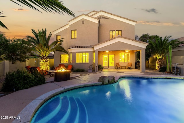 back of house with a patio, a fire pit, stucco siding, and a tile roof