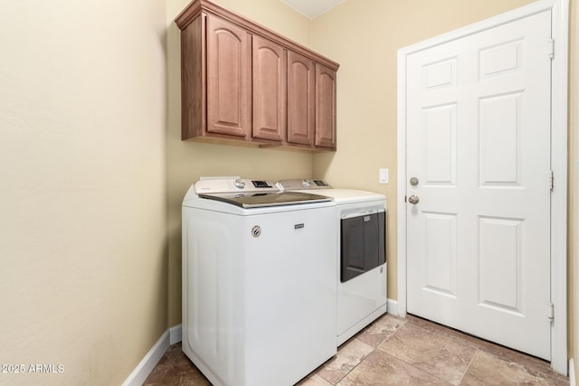 laundry room featuring baseboards, cabinet space, and washing machine and clothes dryer