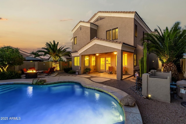 view of swimming pool with a fenced in pool, a patio, a fenced backyard, and a fire pit