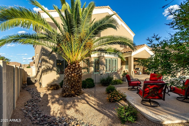 exterior space featuring a patio, cooling unit, stucco siding, and fence