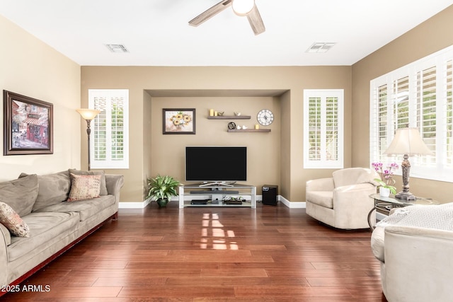 living room featuring baseboards, plenty of natural light, a ceiling fan, and wood finished floors