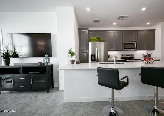 kitchen featuring a kitchen bar, sink, and stainless steel appliances