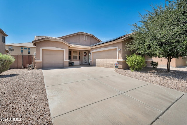 ranch-style home featuring solar panels, concrete driveway, an attached garage, and stucco siding