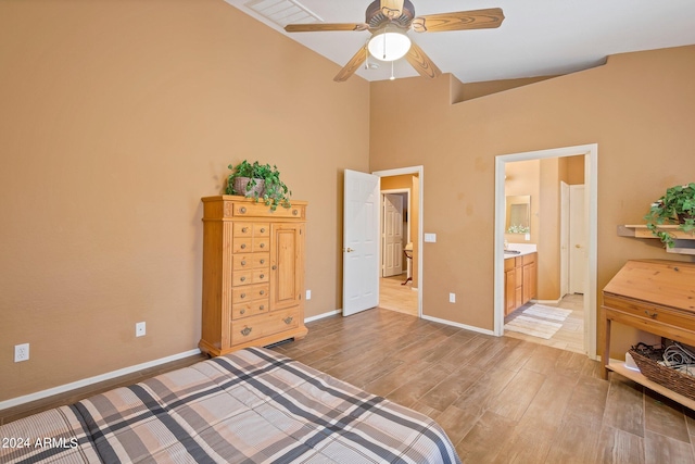 bedroom with light wood finished floors, a ceiling fan, baseboards, and connected bathroom