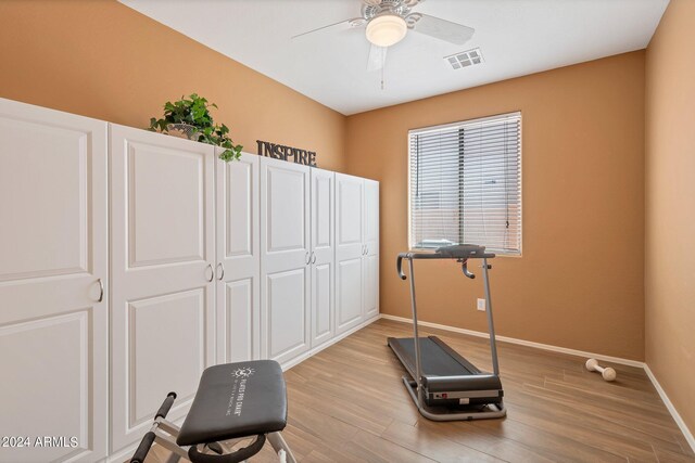 exercise room featuring ceiling fan and light hardwood / wood-style floors