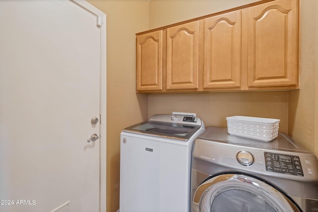 laundry room with cabinets and washer and dryer