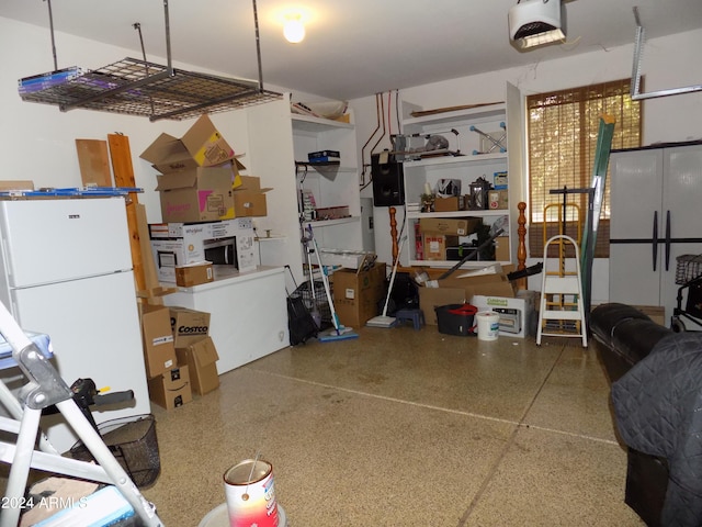 garage featuring a garage door opener and freestanding refrigerator