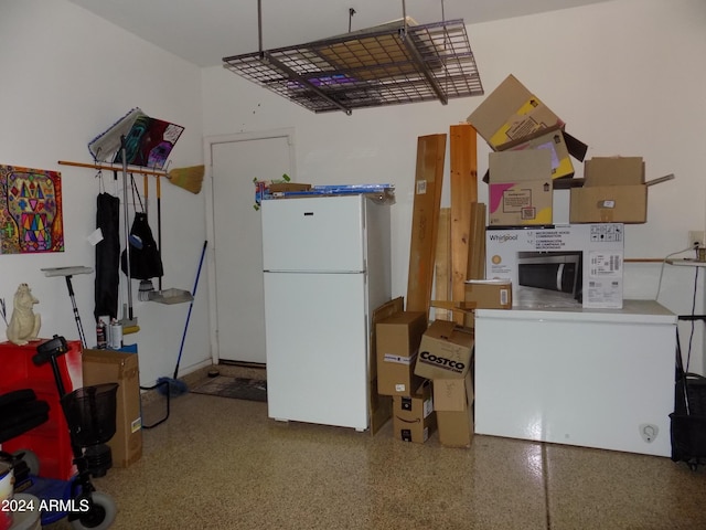 kitchen with speckled floor and freestanding refrigerator