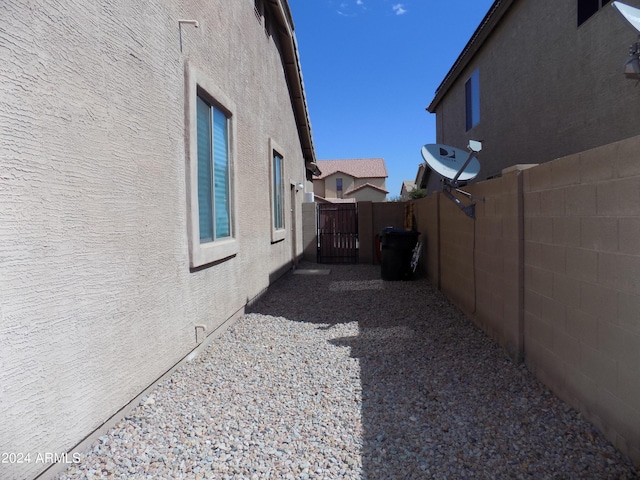 view of property exterior with fence, a gate, and stucco siding