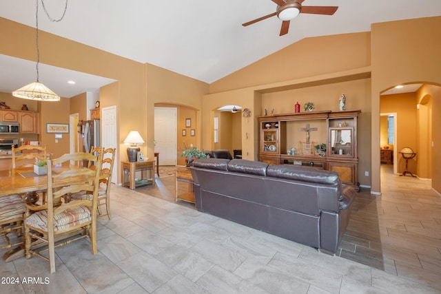 living area with high vaulted ceiling, arched walkways, and ceiling fan