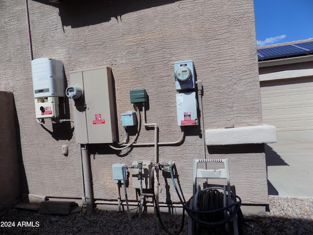 details featuring electric meter and stucco siding