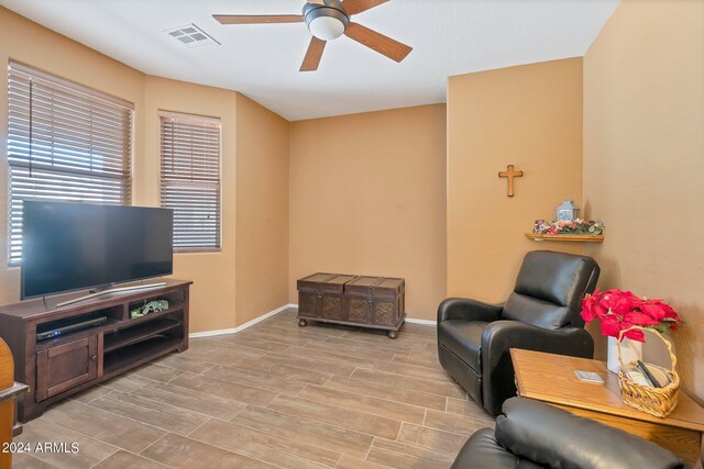 sitting room with ceiling fan and light hardwood / wood-style flooring