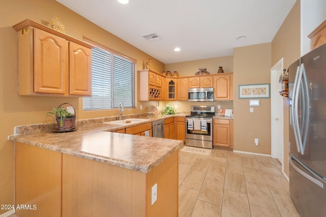 kitchen featuring visible vents, a peninsula, stainless steel appliances, light countertops, and a sink