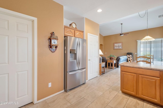 kitchen with decorative light fixtures, light countertops, visible vents, vaulted ceiling, and stainless steel fridge with ice dispenser