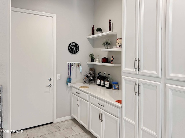 bar featuring white cabinets and light tile patterned flooring