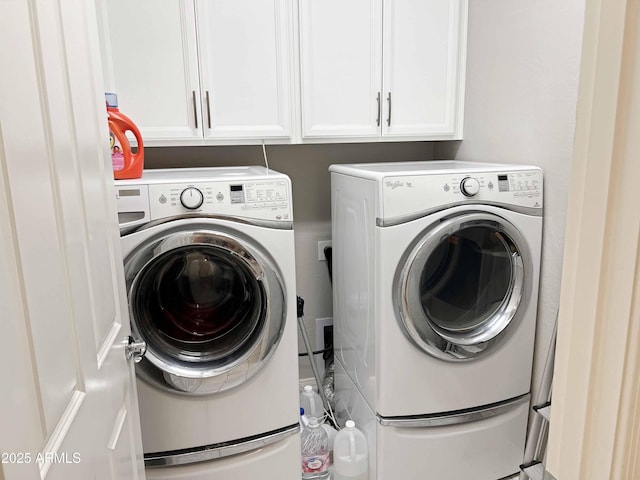 laundry area with washing machine and dryer and cabinets