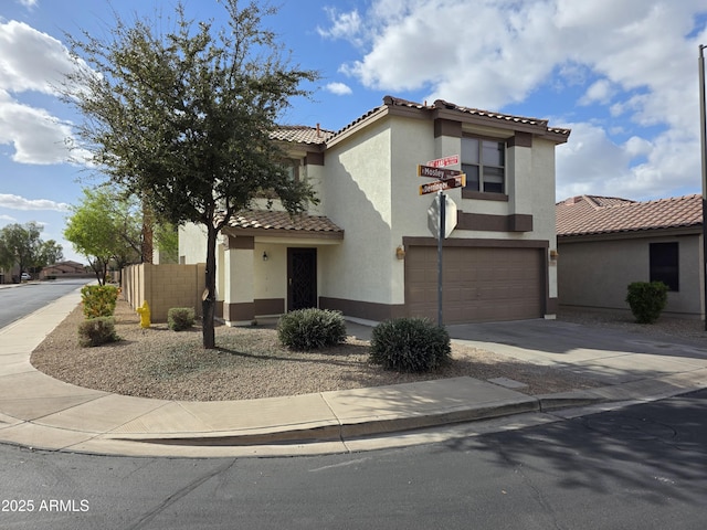 mediterranean / spanish home featuring a tiled roof, an attached garage, driveway, and stucco siding