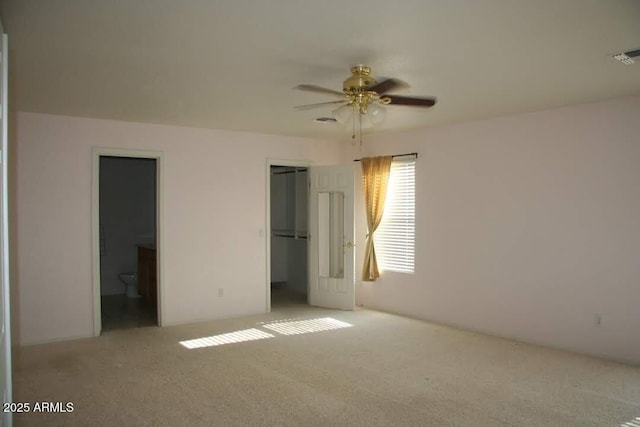 unfurnished bedroom with a ceiling fan, visible vents, a closet, carpet flooring, and connected bathroom