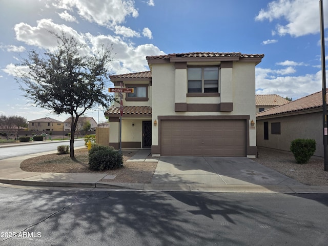 mediterranean / spanish-style house with stucco siding, a tiled roof, driveway, and a garage