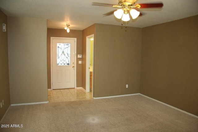 entrance foyer featuring baseboards, light carpet, and a ceiling fan