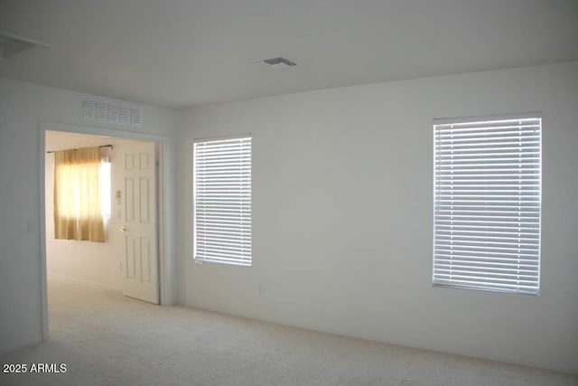 carpeted spare room featuring visible vents