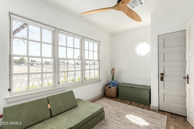 living area with ceiling fan, wood finished floors, and visible vents