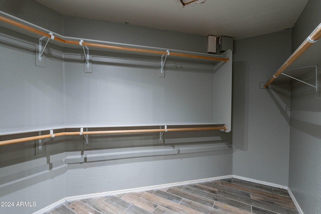 walk in closet with wood finished floors
