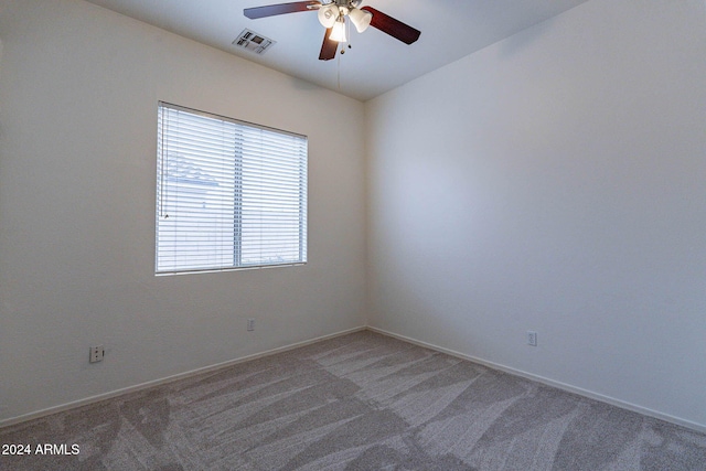 carpeted empty room with baseboards, visible vents, and ceiling fan