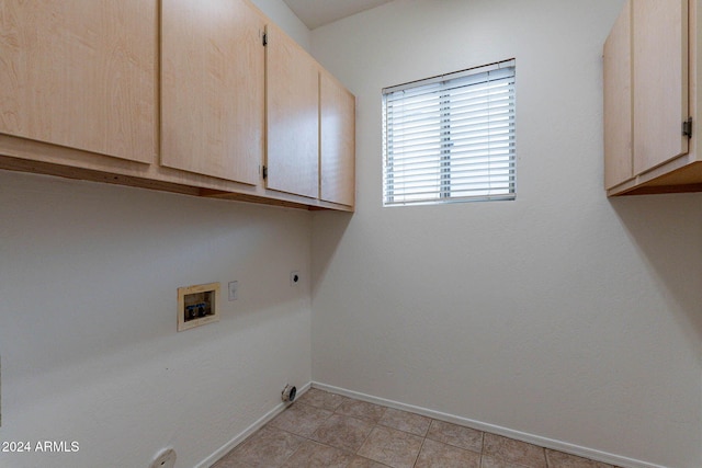 laundry room featuring cabinets, hookup for an electric dryer, hookup for a washing machine, and light tile patterned floors