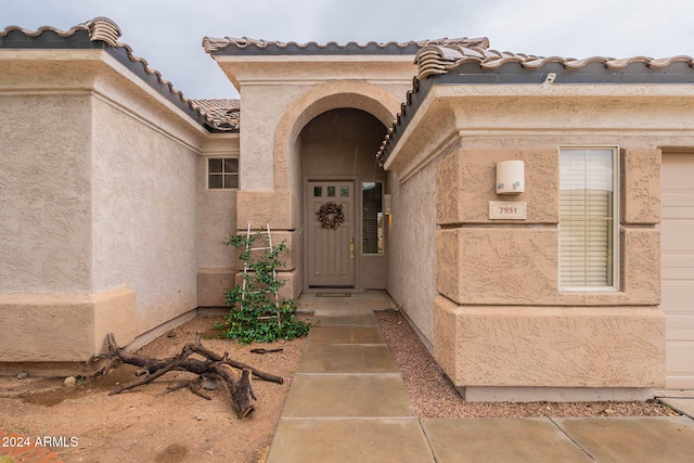 entrance to property with stucco siding and a tiled roof