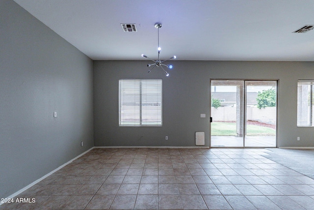 unfurnished room featuring a chandelier and light tile patterned floors