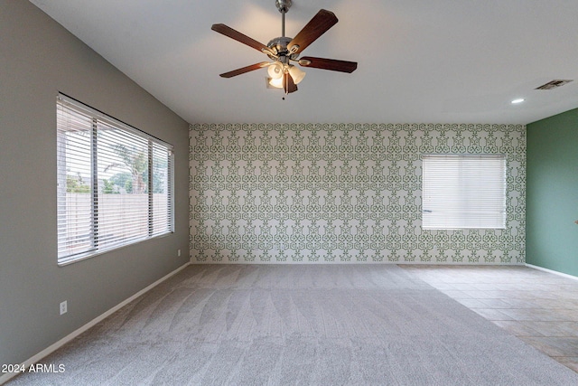 unfurnished room featuring baseboards, visible vents, and a wealth of natural light